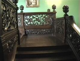 The ornate wooden staircase between the ground floor sculpture gallery and the first floor at Carbisdale Castle